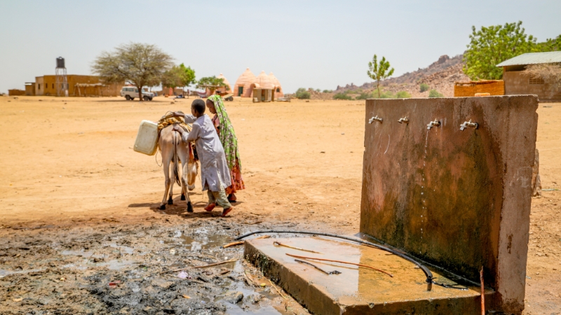 Gebären ohne Wasser - das ist die Realität Kinder transportieren Wasser von einer Wassterstelle, Tschad
