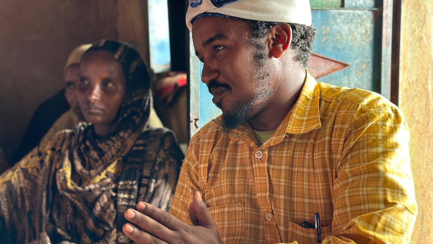 Scheich Ein Mann mit Turban spricht zu einer Gruppe.