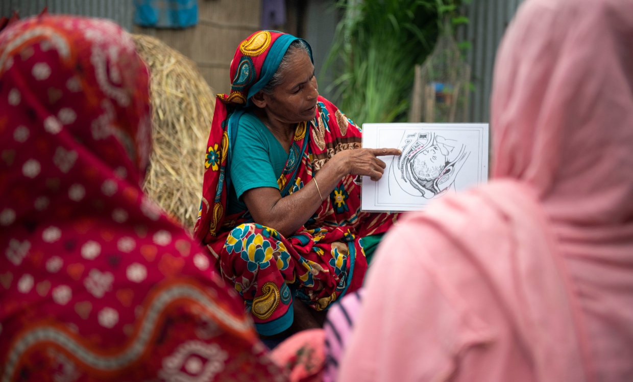 Unterstützung bei Geburtsfisteln Eine Frau erklärt etwas und zeigt mit dem Finger auf eine Illustration.