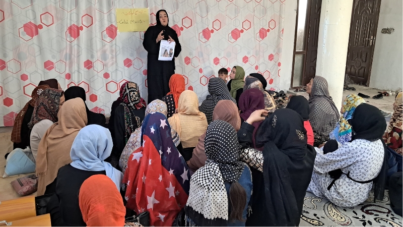 Frauen stärken Frauen Eine Frau spricht stehend vor einer sitzenden Gruppe.
