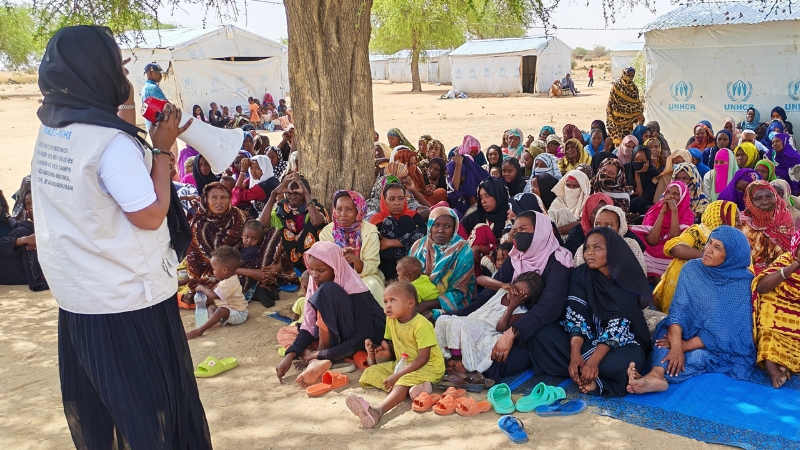 Tschad: Gesundheitssystem am Limit, wegen des Kriegs im Sudan Eine Frau spricht vor vielen sitzenden Frauen.