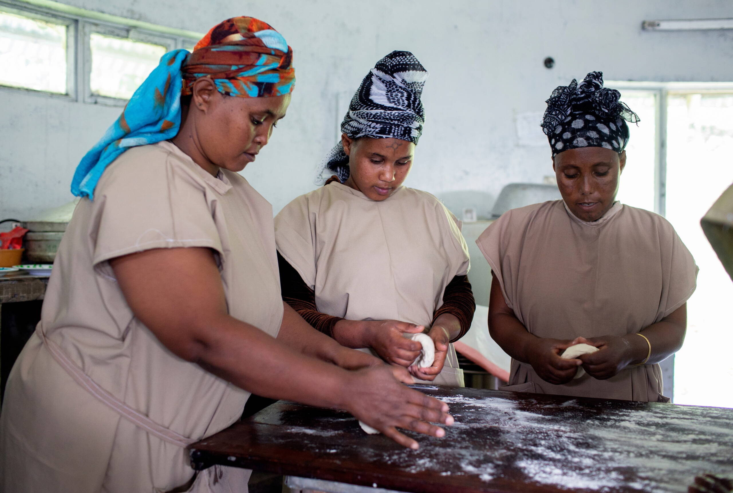 Catering-Kurs Drei Frauen kneten Teig.